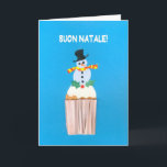 Cartão de Natal, italiano, cupcake com boneco de<br><div class="desc">Um cartão de Natal italiano brilhante e alegre com uma árvore de Natal decorada sobre um cupcake congelado, de uma colagem de papel pintado à mão por Judy Adamson. O cumprimento dianteiro, no texto branco em um fundo azul, é "Buon Natale!" e a mensagem interna, que você pode mudar, é,...</div>