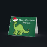 Cartão Dinossauro de Natal bonito em Santa Hat Verde<br><div class="desc">Incrível dinossauro verde sorrindo e parecendo muito fofo em um chapéu vermelho de Papai Noel. As crianças vão adorar este legal cartão verde de férias. Personalize esses cartões de Natal com seu próprio texto em branco.</div>