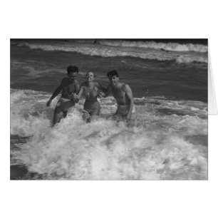 Cartão Dois jovens homens e mulheres jogando na onda B&W