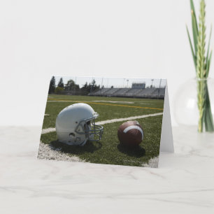 Cartão Football and football helmet on football field