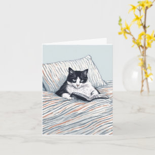 Cartão gato lendo na cama