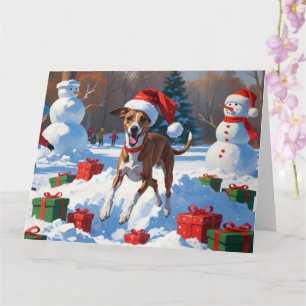 Cartão Greyhound Correndo na Neve com Chapéu de Natal