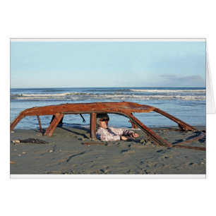 Cartão Homem que senta-se no carro oxidado na praia