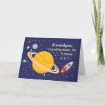 Cartão Planetas do aniversário do neto no espaço, Rocket<br><div class="desc">Deseje a seu neto um o feliz aniversario que é fora deste mundo! Saturn é visto na cor amarela dourada com as estrelas e os outros planetas que cercam a. Um navio do foguete apenas soprou fora para desejar o feliz aniversario.</div>