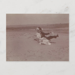 Cartão Postal 2 pessoas na praia perdendo chapéus