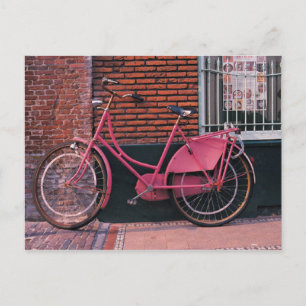 Cartão Postal Bicicleta Cor-de-Rosa Encostada a Parede de Tijolo
