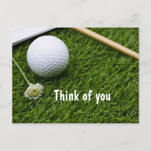 Cartão Postal Bola de golfe com uma pequena flor na grama, pense