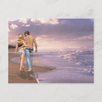 Casal apaixonado caminhando na praia ao pôr do sol