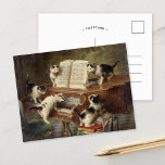 Cartão Postal Considerando "Kittens" | Carl Reichert<br><div class="desc">Considerando dos Kittens (1908) | O considerando "The Kittens", de Carl Reichert, é uma pintura encantadora e imaginativa que inclui cinco gatinhos adoráveis reunidos em torno de um piano, aparentemente fazendo um recital. A única pose de cada gatinho e a expressão lúdica trazem personalidade para a cena, enquanto o piano...</div>