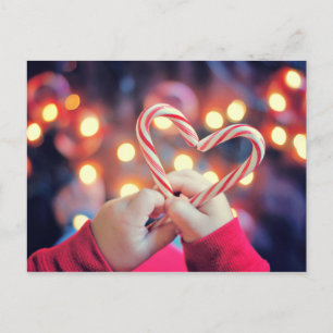 Cartão Postal De Festividades Child holding Christmas candy with heart shape