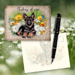 Cartão Postal German Shepherd Dog in Wildflowers Custom Postcard<br><div class="desc">Thinking of you, German Shepherd dog postcard. White daisies, yellow calendula, palmetto palm fronds and a blue butterfly surround a sweet pup lying in a bed of flowers. Background image is dark linen fabric (design only) with black script along the top that is easy to change to your choice of...</div>