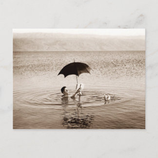 Cartão Postal Homem lendo sob guarda-chuva no mar do Morto