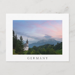 Cartão Postal Igreja com montanhas alpinas no pôr do sol