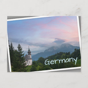 Cartão Postal Igreja com montanhas alpinas no pôr do sol