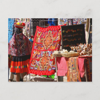 Cartão Postal Mulher indiana peruana olhando têxteis coloridos