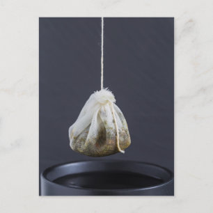 Cartão Postal O saco de chá está pendurado em uma xícara