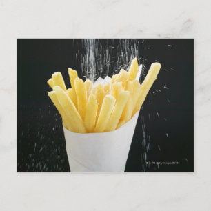 Cartão Postal Polvilhando sal em batatas fritas em cone de papel
