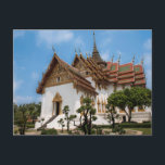 Cartão Postal Postcard of a scenic temple in Thailand<br><div class="desc">Photo of a dazzling white temple under a blue sky. The temple,  in the heart of Thailand,  has gold trimmings and traditional Thai architecture  It is surrounded by trees. Stairs lead to one of the entrances. The roof is red and Thai art adorns the outside of the temple.</div>