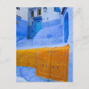 Cartão Postal Rugs Embrulhados Em Uma Parede Azul