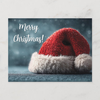 Cartão Postal Santa Hat Resting on Snowy Surface with Greeting