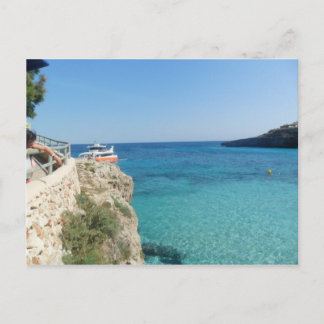 Cartão Postal Sol, mar e um pequeno barco laranja