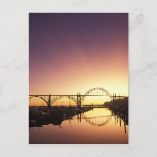 Cartão Postal Sol se pondo atrás da ponte de Newport, Oregon