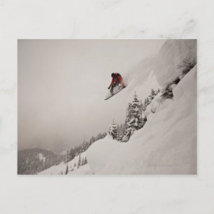 Cartão Postal Um praticante de snowboard pula de um penhasco par