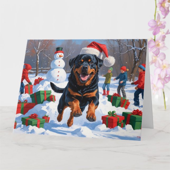 Cartão Rottweiler correndo em neve com chapéu de Natal (Orquídea)