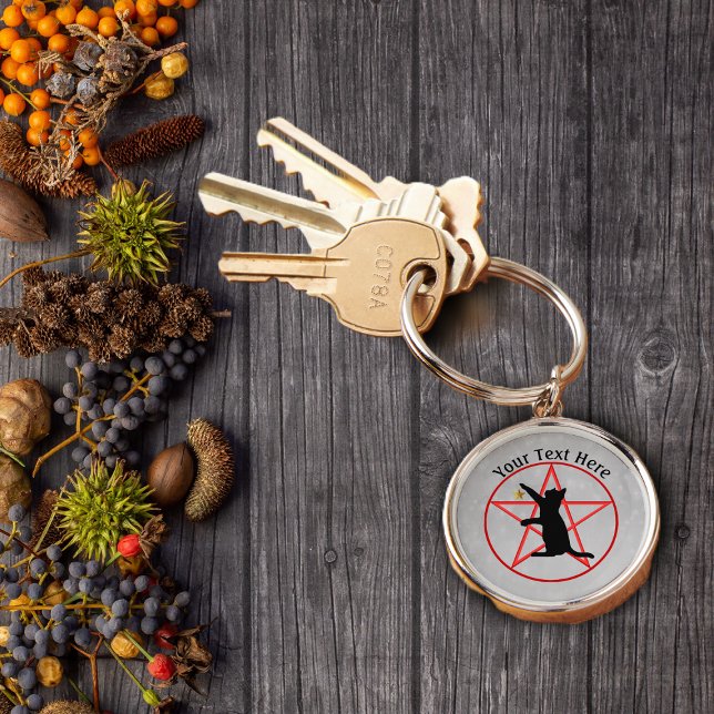Chaveiro Dourada Estrela Vermelha Pentagrama em Cinza (Black witch cat holding up gold star on red pentagram in circle on grey keychain.)
