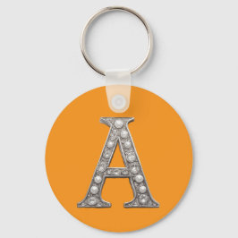 Chaveiro Letra A com Joias Sobre Fundo Amarelo