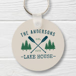 Chaveiro Nome da família Lago House Oars Russos Pine Tree R<br><div class="desc">Um belo e rústico chaveiro redondo com seu nome familiar e casa do lago, cabana, cabana ou outro texto desejado e sua data estabelecida, tudo em tipografia rústica. Este design exclusivo e personalizado apresenta remos, remos, remos e pinheiros azuis em verde macio. A cor de base do creme de designs...</div>