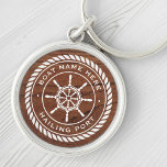 Chaveiro Nome do barco que enche a madeira de roda do navio<br><div class="desc">Tecla com um emblema branco e elegante da roda e da corda de um navio com nome de barco personalizado e porto de cabeleireiro (ou outro texto personalizado) numa imagem impressa de madeira marrom.</div>