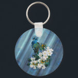 Chaveiro Peacocks e Emerald Green Metalical Silk<br><div class="desc">Dois Peacocks imperiais com colchetes finos terminando numa longa e extravagante cauda decorativa de penas impressionantes enroladas em torno de fragrantes flores brancas Frangipani num esmeraldo metálico verde-esmeralda texturizado padrão de pavão</div>