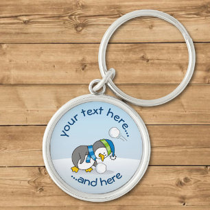 Chaveiro Pequeno pinguim pegando uma bola de neve