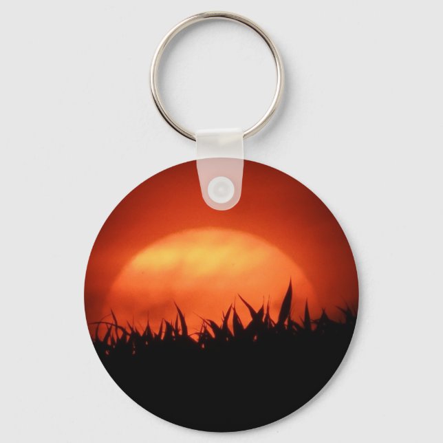 Chaveiro Sol vermelho atrás da grama preta (Frente)