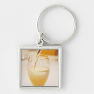 Chaveiro Uma taça de flûte sendo enchida com Gosset
