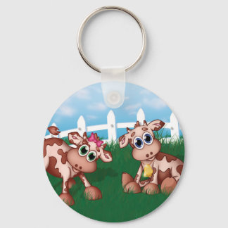 Chaveiro Vacas-bebê do lado de morro com cerca branca nas c