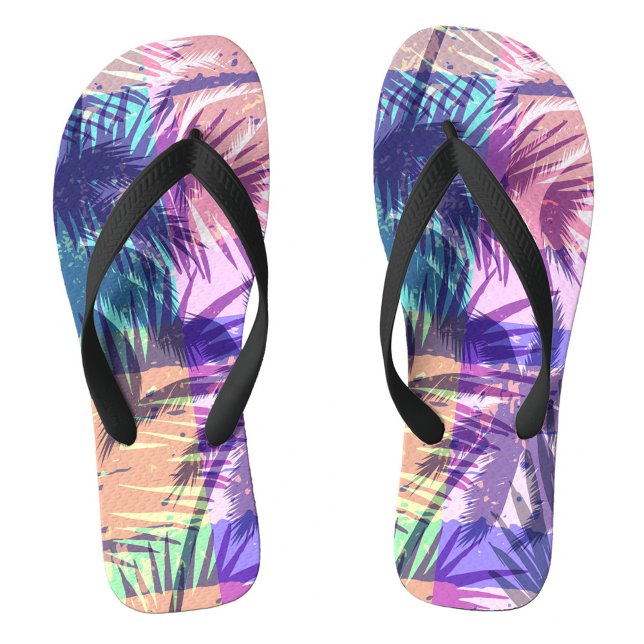 Chinelos Exótico (A palm leaf patterns in vivid colors. The background reveals gentle waves lapping at the shore.  )