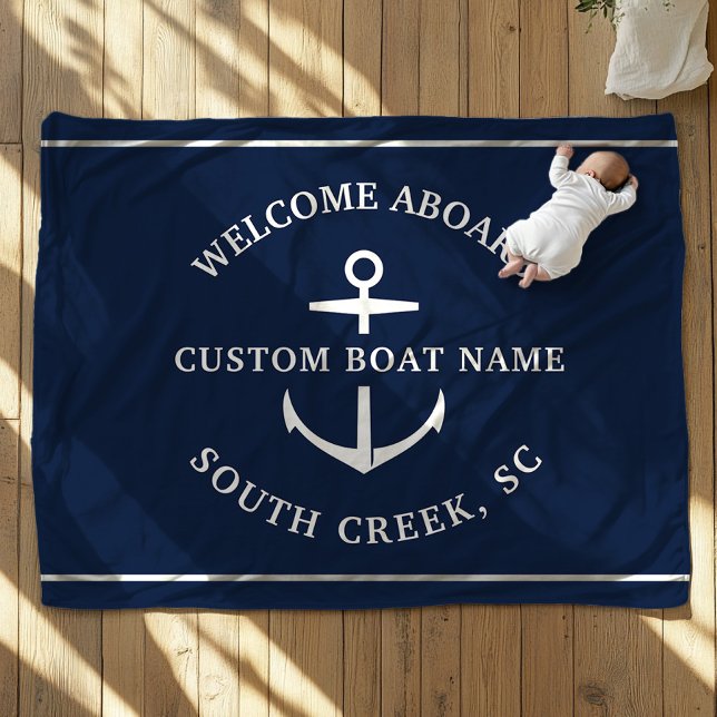 Cobertor De Velo Nome do Barco Personalizado Moderno Bem-vindo a Bo (A baby, dressed in white, lies on a navy blue blanket with an anchor motif. Text is Welcome Aboard")