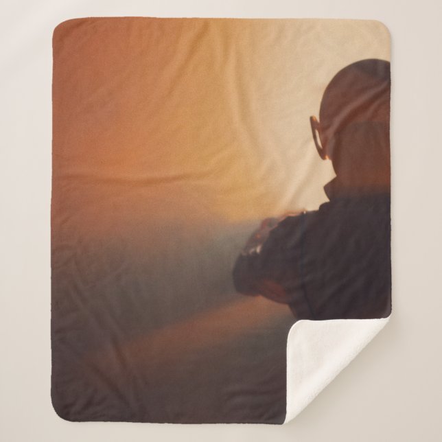 COBERTOR SHERPA HOMEM EM JAQUETA PRETA VESTINDO BONÉ PRETO (Frente)