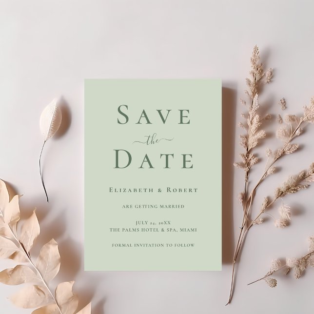 Convites Minimalista Moderno Suave Verde Salva a Data (Modern Minimalist Soft Sage Green Save the Date Invitation on a table with blush pink flowers.)