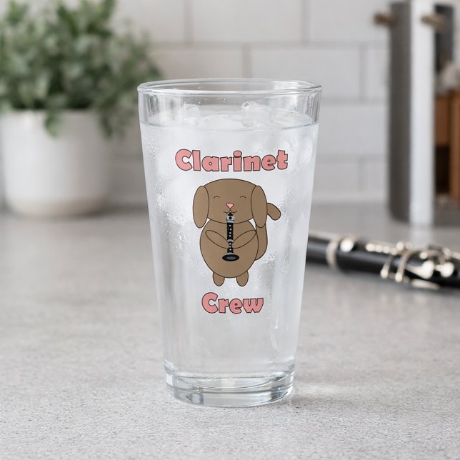 Copo De Pint Equipe de Clarinete Fofa Cachorro Marrom Tocando C (A glass with a cute dog playing the clarinet and the words clarinet crew in pink letters.)