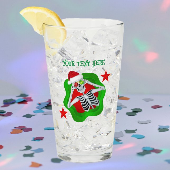 Copo De Pint Olhos de Ornamento do Esqueleto de Natal Inchado n (Silly skeleton ornament eyes splatter shape red stars on Merry Christmas glass drink tumbler.)