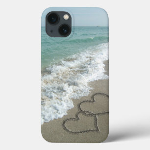 Corações de bloqueio na areia da praia