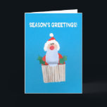 Cupcake do cartão de Natal com Papai Noel<br><div class="desc">Um cartão de Natal brilhante e alegre com papai noel e algum azevinho sobre um cupcake congelado, de uma colagem de papel pintado à mão por Judy Adamson. O cumprimento dianteiro, no texto branco em um fundo azul, é da "os cumprimentos estação!" e o interior é deixado vazio para sua...</div>