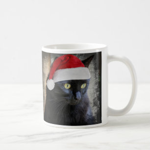 De Café Gato bonito do Natal no papai noel chapéu, caneca