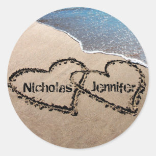 Dois corações na praia da areia selam etiquetas