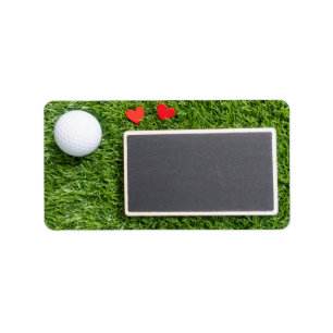 Etiqueta A bola de golfe com dois corações está verde co