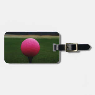 Etiqueta De Bagagem Bola de golfe cor-de-rosa em um campo de golfe da