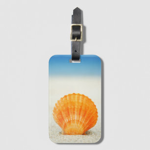 Etiqueta De Bagagem Scallop Shell alaranjado que está ereto na areia